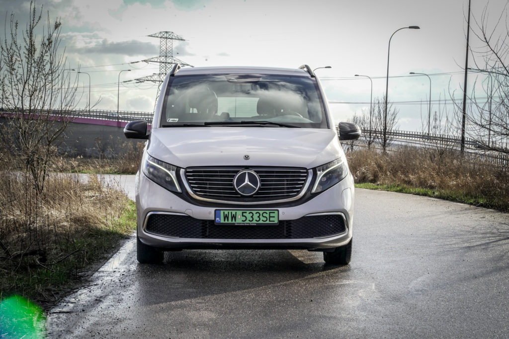 srebrny Mercedes EQV stojący na wilgotnym asfalcie bocznej drogi