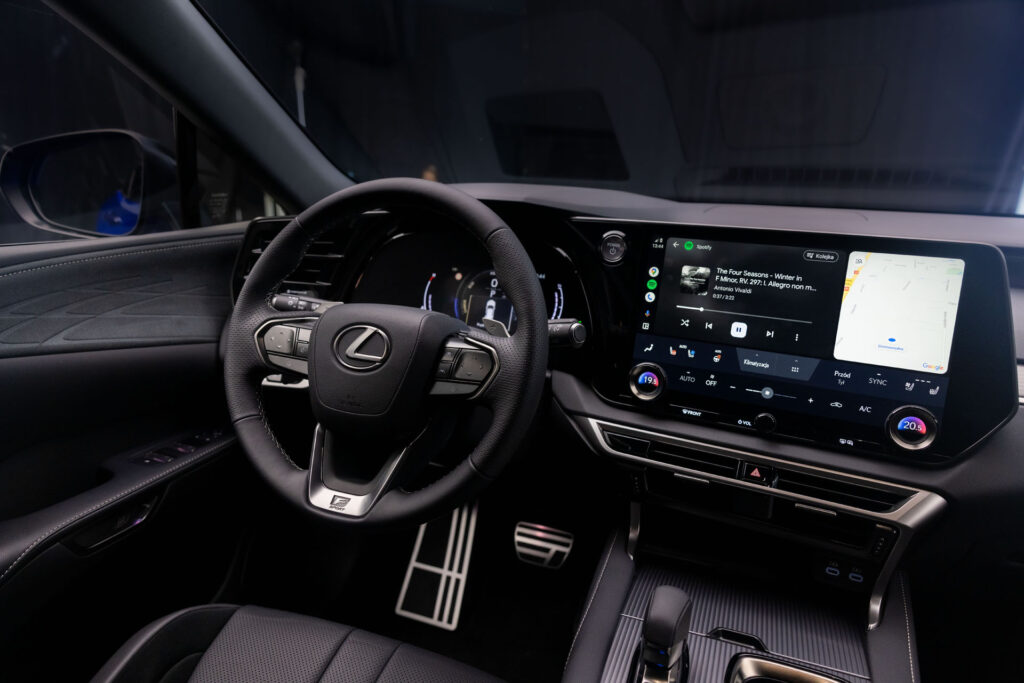 Wnętrze Lexusa RX 500h widok na system multimedialny, zegary i kierownicę