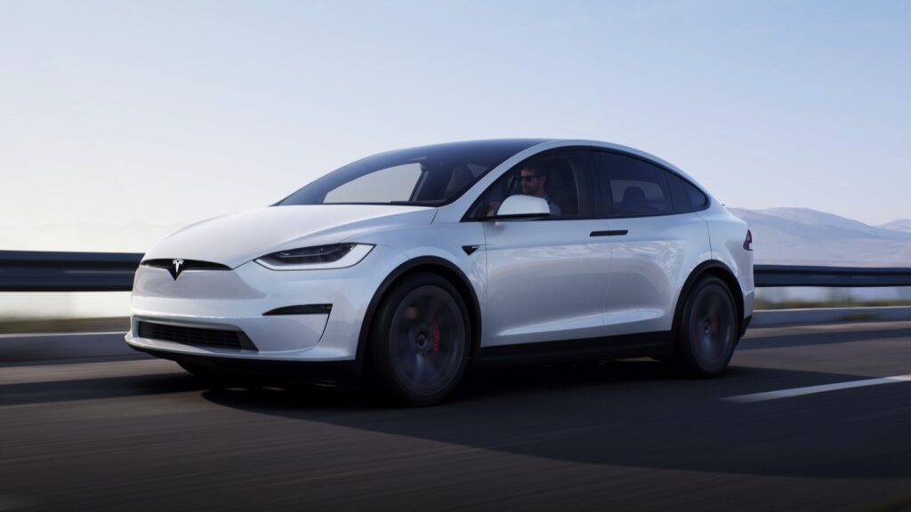 Biała Tesla X Plaid jedzie szybko po drodze