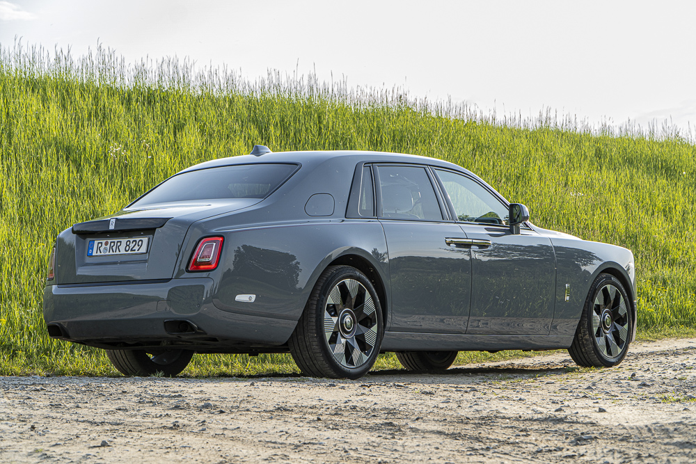 szary Rolls-Royce Phantom tojący na polnej drodze na tle trawy